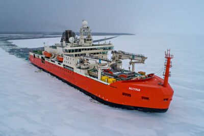 A red icebreaker ship cuts a swathe through ice RSV Nuyina is the Australian Antarctic Program's platform for supporting marine and atmospheric science Photo: Pete Harmsen